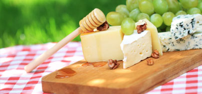 Picture of a picnic blanket with cheese and fruit