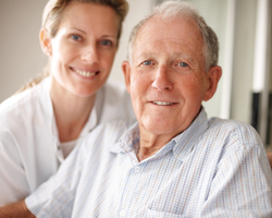 Closeup of a happy retired man on the wheel chair with a nurse